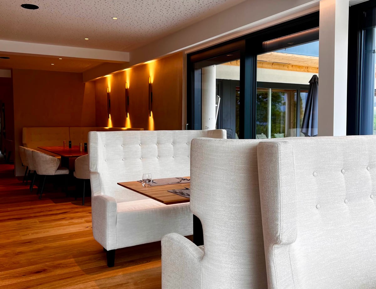 Modernes Restaurant im Landhaus Ramsau mit eleganten Sofas und Holzböden