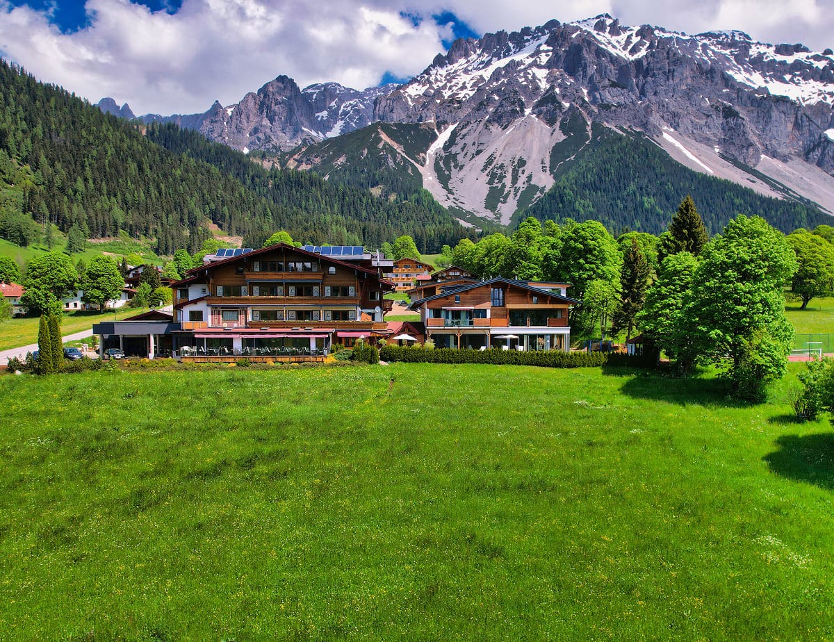 Landhaus Ramsau in grüner Landschaft vor dem Dachsteinmassiv